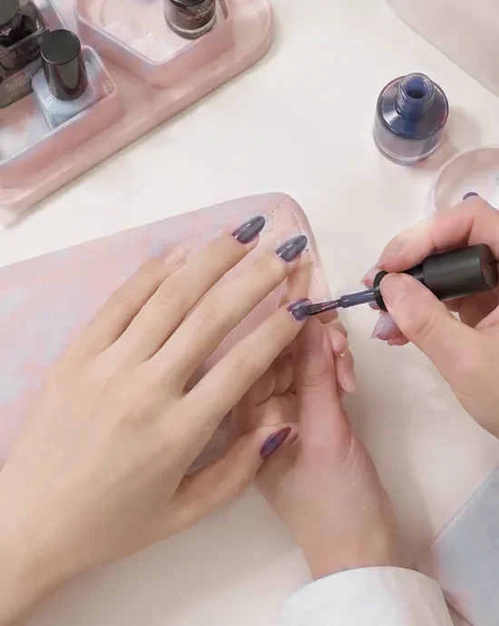 Polish painted onto almond nails in slow, even strokes